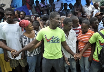 Men hold back a crowd at a food distribution in the Santa Teresa camp in Petionville, Haiti. Hundreds of families left homeless by the Jan. 12 earthquake live here. The ACT Alliance provides a variety of services in this camp. PHOTO BY PAUL JEFFREY/ACT ALLIANCE