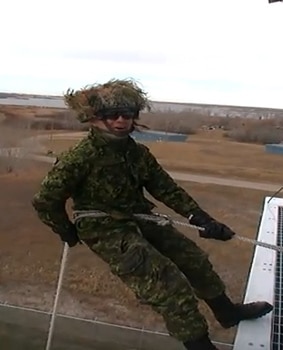 A recruit sings "Silent Night" while rappeling down a 60-foot training wall in Wainwright, Alta.