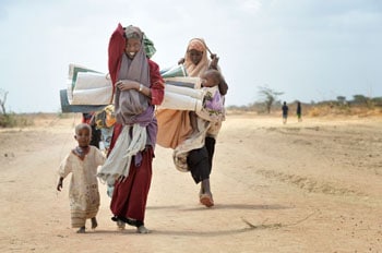 Somalian Habiba Ibrahim Ali, 20, walks with another woman and their children to a new extension of the world's largest refugee settlement: the Dadaab camp in northeastern Kenya. ACT/PAUL JEFFREY