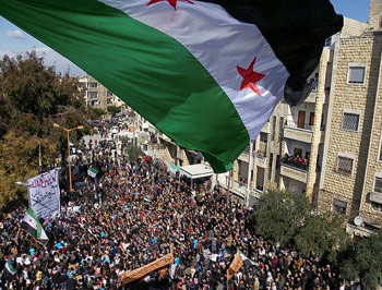 A Syrian independence flag flies over a large gathering of protesters in Idlib, Syria. FREEDOMHOUSE ON FLICKR