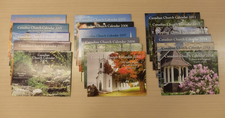 A collection of calendars featuring scenic photographs of churches, showcasing various designs and months, arranged neatly on a surface.
