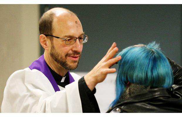 Pappas applies ashes to an Edmonton commuter as part of the diocesan Ashes to Go program, which offers ashes and blessings to city residents on Ash Wednesday. Photo by Margaret Marschall