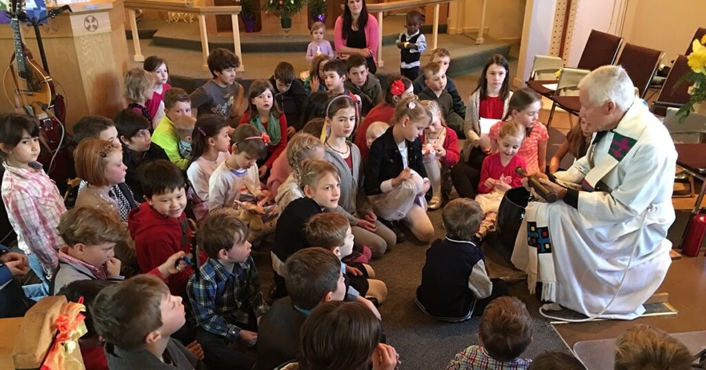 A diverse group of children sitting on the floor, engaged and listening attentively during a storytelling session in a cozy indoor setting.
