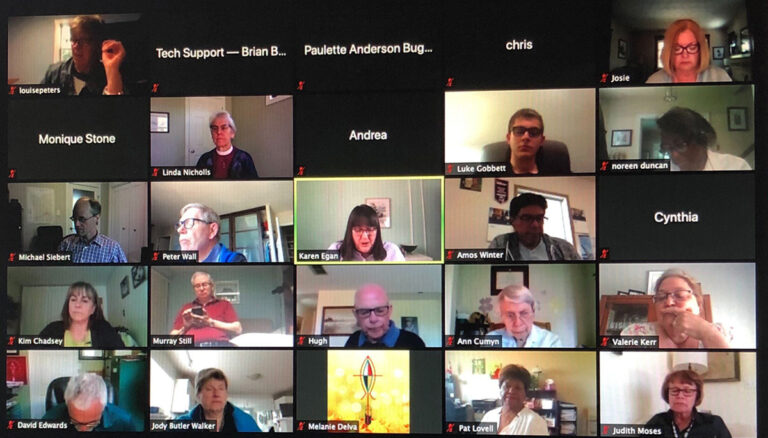 Group video call featuring multiple participants engaged in discussion, with a focus on a central speaker. The layout shows a grid of faces, indicating an interactive online meeting environment.