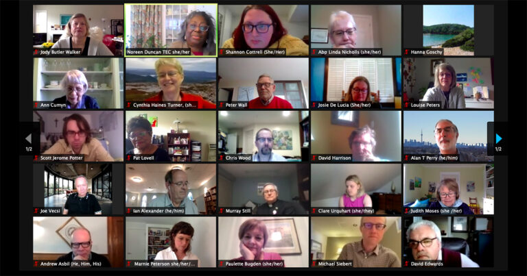 A virtual meeting with multiple participants displayed in a grid format, featuring individuals engaged in discussion. Some participants are focused on their screens, while others appear to be speaking or listening attentively. The background includes various home office settings.