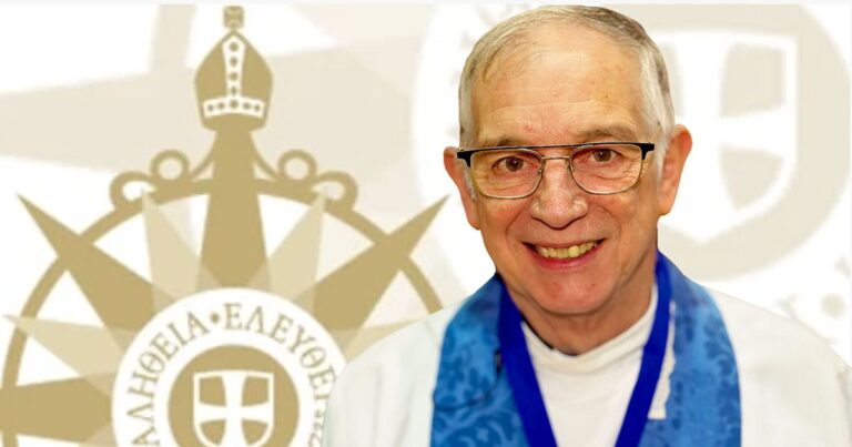 Portrait of an older man with glasses, smiling and wearing a blue sash, against a background featuring a decorative emblem with a crown and the words "ΑΛΗΘΕΙΑ•ΕΛΕΥΘΕΡΙΑ." The image conveys a sense of achievement and recognition.
