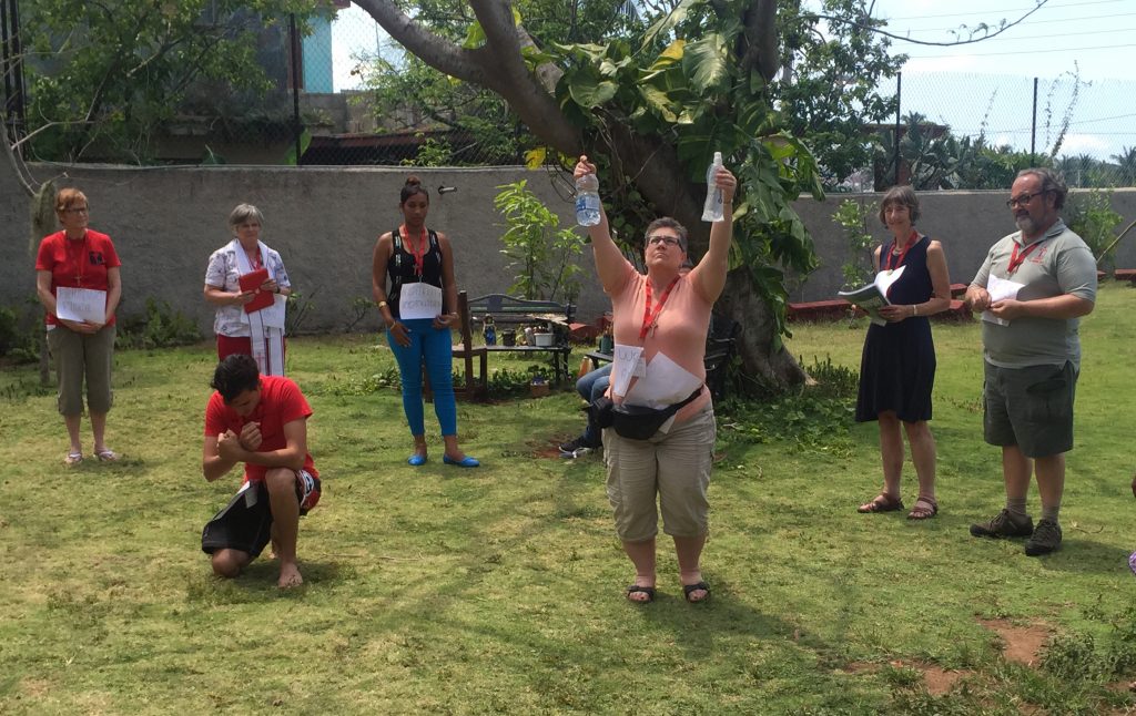 Representing "water," Canadian participant Robyn Michell raises two water bottles as part of the food security immersion group's report. 