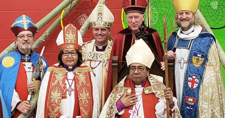Group of four individuals dressed in ceremonial religious attire, including mitres and robes, posing together in a vibrant setting. The image captures their formal expressions and the ornate details of their garments, highlighting a significant religious event.
