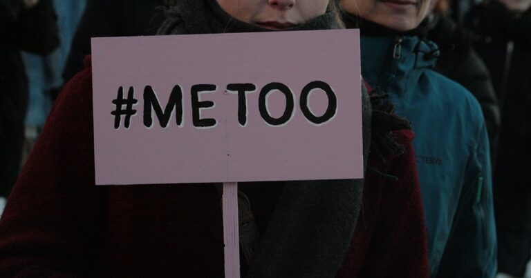 A close-up of a protest sign displaying the hashtag #MeToo, held by an anonymous individual at a demonstration advocating for social change and awareness around sexual harassment and assault.