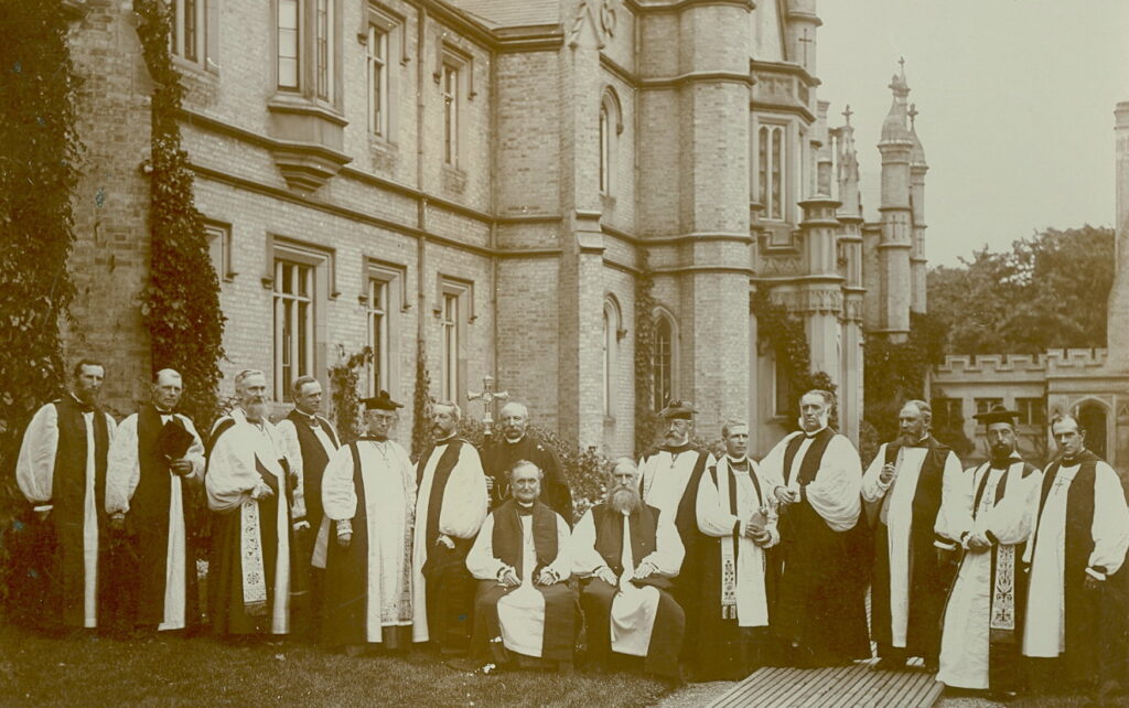 Fifteen robed bishops pose outside Trinity College.
