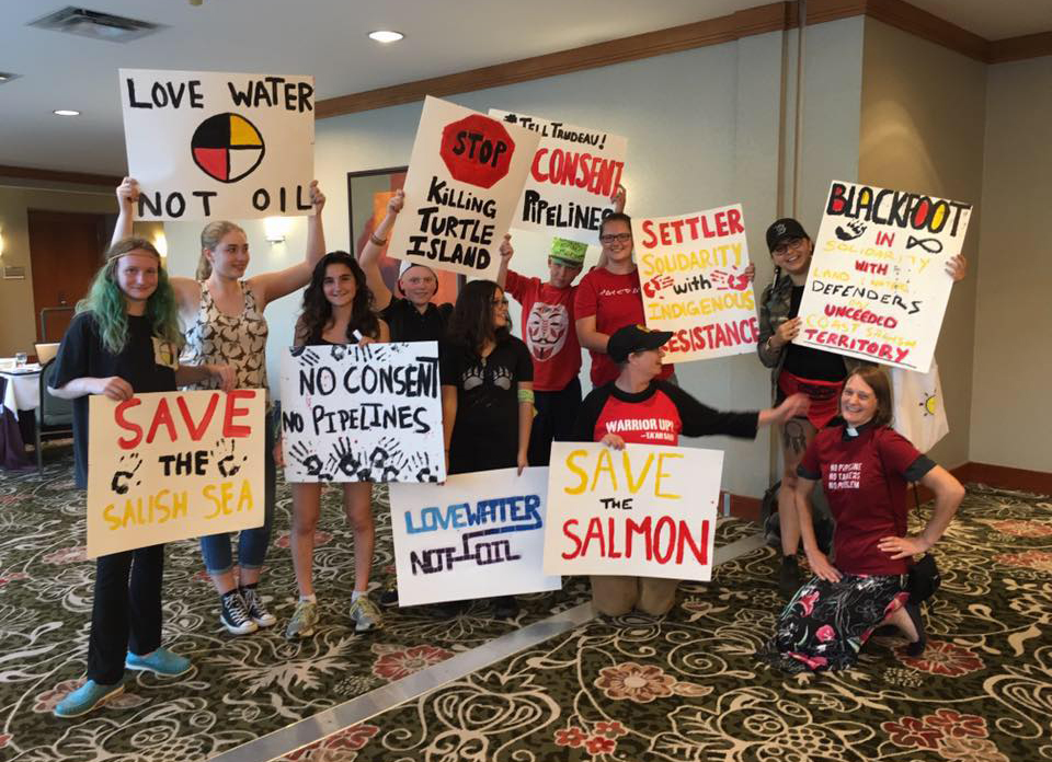 Sacred Earth Camp participants hold signs outside the Kinder Morgan hearings after speaking out against the Trans Mountain expansion project. Submitted photo by Devin Gillan