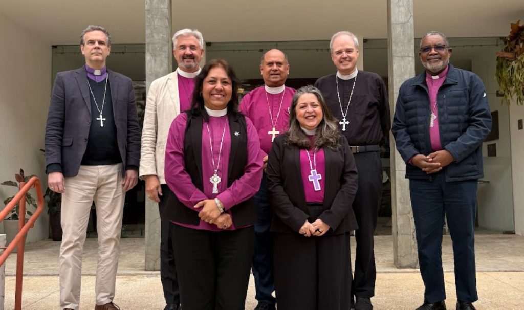 Back row (L-R): Presiding Bishop Brian Williams of the Anglican Church of South America, The primates of North, Central and South America stand in rows on concrete steps in front of a concrete building. They are: Back row (L-R): Presiding Bishop Brian Williams of the Anglican Church of South America, Archbishop Shane Parker, primate of the Anglican Church of Canada, Archbishop Juan David Alvarado Melgar, former archbishop of Guatemala, Presiding Bishop Sean Rowe of the Episcopal Church, Archbishop Philip Wright, Primate of the West Indies. Front row (L-R): Archbishop Alba Sally Sue Hernandez, primate of the Anglican Church of Mexico, Archbishop Marinez Bassotto, primate of the Anglican Church of Mexico