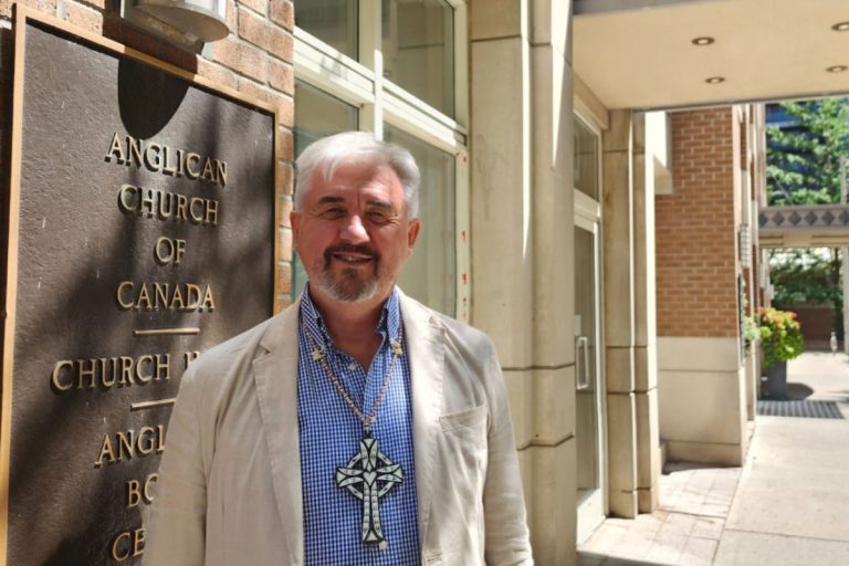Archbishop Shane Parker, primate of the Anglican Church of Canada, stands outside Church House, the church's national office, wearing a cross presented to a previous primate by residents of the Solomon Islands. Photo: Sean Frankling
