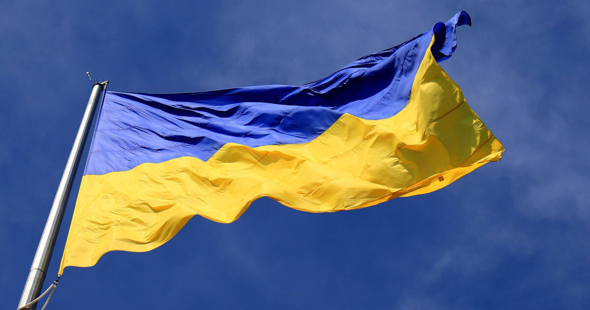 Picture of the Ukrainian flag, blue and yellow colours, against the background of a blue sky.