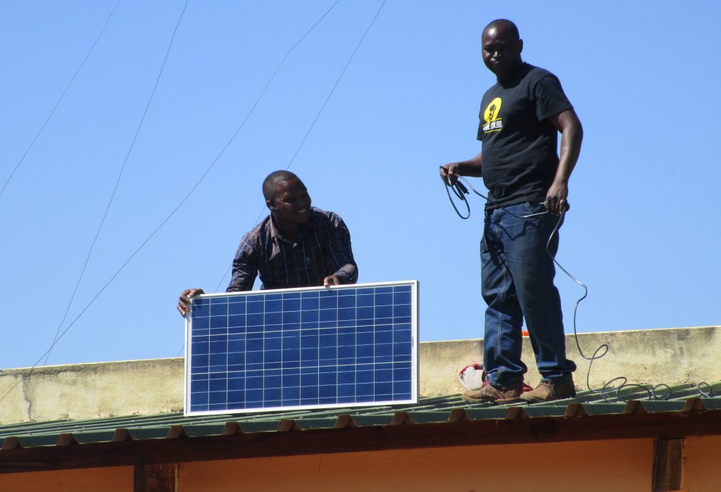 Installation of solar panels on the roof of of a health clinic to power solar suitcase. Submitted photo by PWRDF