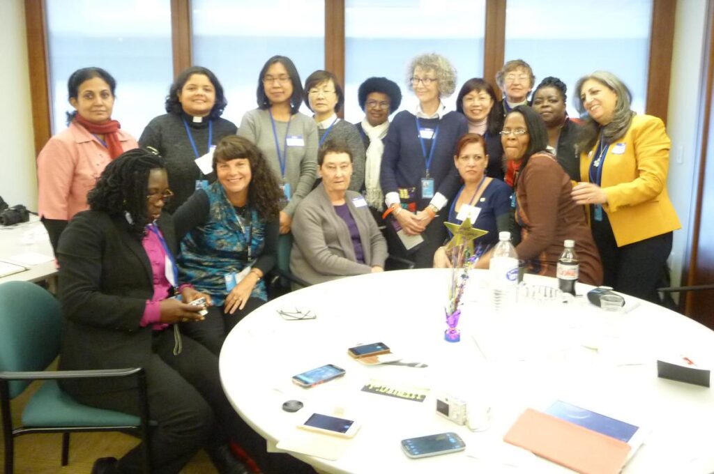 Group of diverse women gathered around a round table, engaging in conversation and collaboration during a meeting or conference.