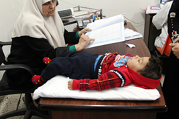 A child lays on a table for examination by a doctor.