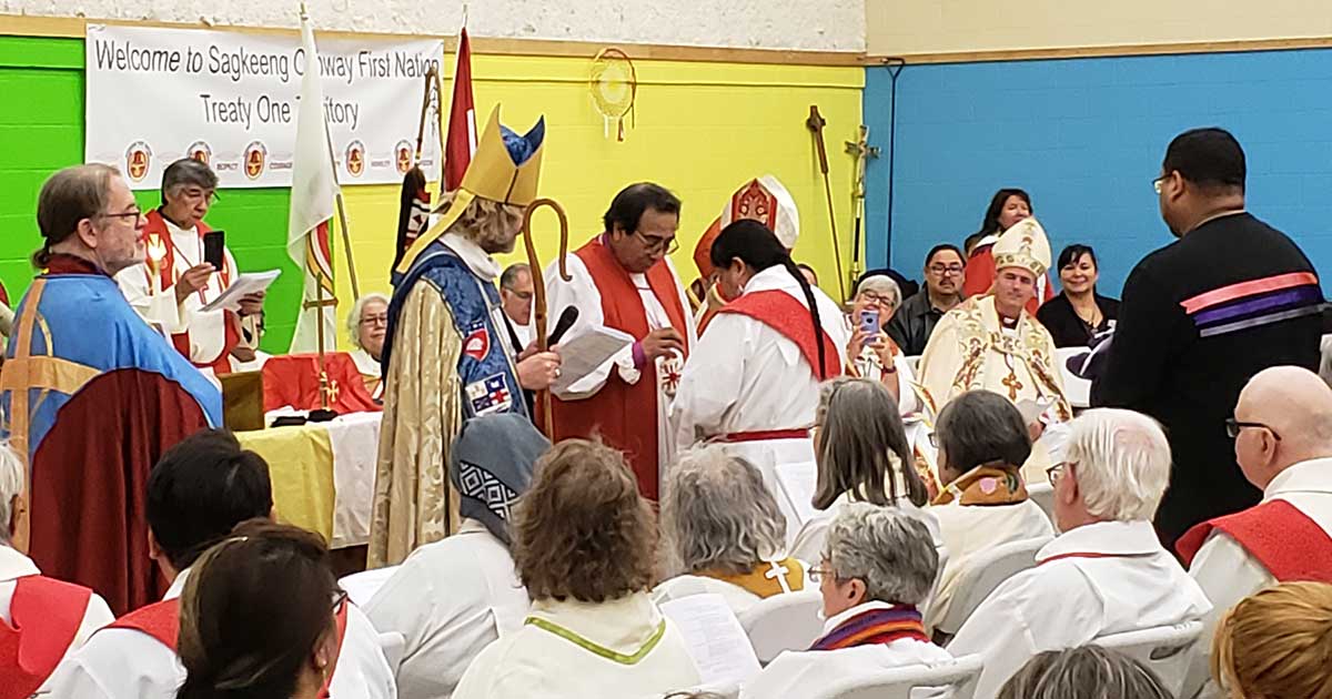 National Indigenous Anglican Bishop Mark McDonald and metropolitan of the ecclesiastical province of Ruperts land Bishop Gregory Kerr-Wilson look on as Bishop Beardy gives sacrament to laity. Photo: Melanie Delva