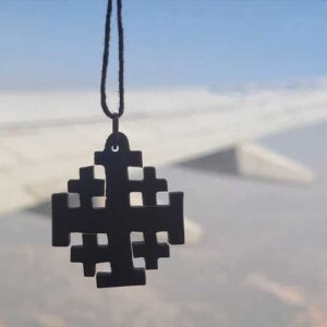 Photo of Jerusalem Cross in front of an airplane wing. Photo taken from the aircraft cabin.