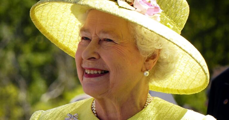 Portrait of a smiling woman wearing a yellow hat and a matching dress, with a garden background. The image captures a warm and cheerful expression.