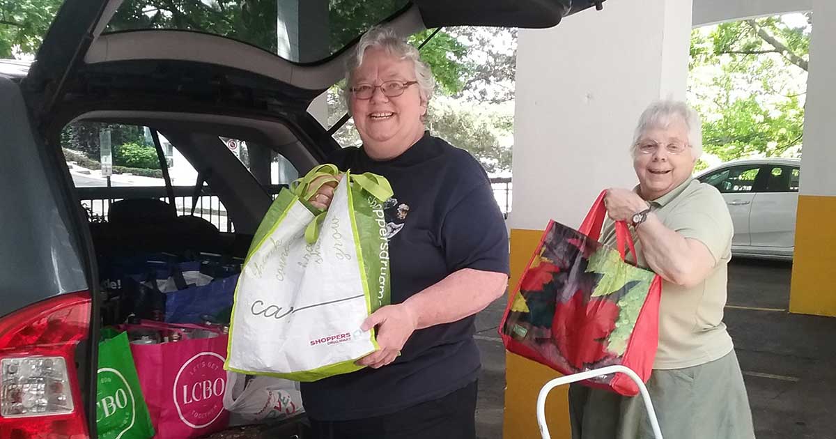 Sister Margaret and Sister Heather are all smiles as they load bags of empty bottles into their car. Photo: courtesty of Sister Margaret Hayward