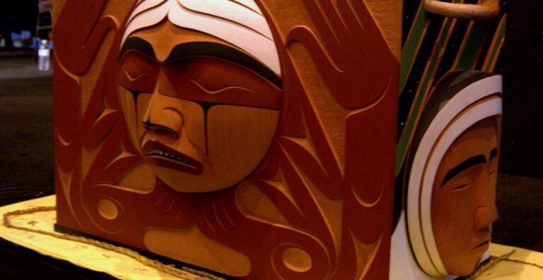 Carved wooden mask featuring a stylized face with intricate details, showcasing traditional Indigenous art and craftsmanship.