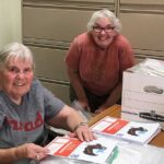 Volunteers help assemble kits for Bible Camp in a Bag.
